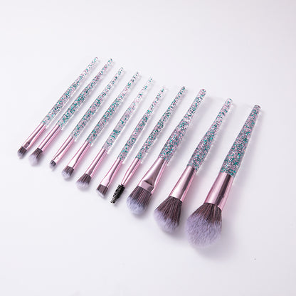 Set of makeup brushes with glittery handles on a white background