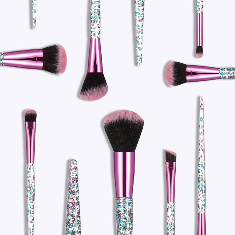 Makeup brushes with pink handles and glittery accents on a white background