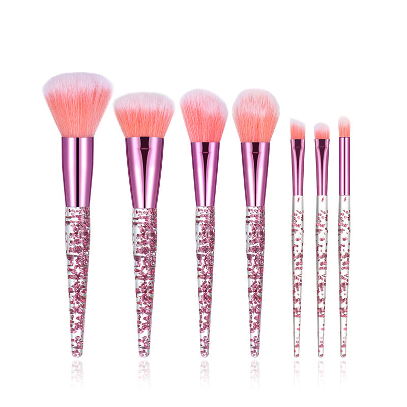Set of makeup brushes with pink bristles and glittery handles on a white background