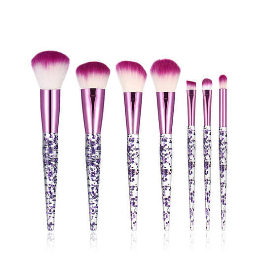 Set of makeup brushes with purple and pink handles on a white background