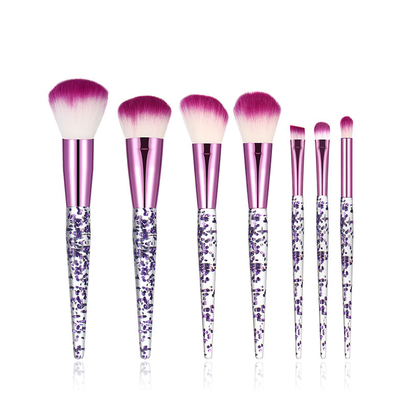 Set of makeup brushes with purple and pink handles on a white background