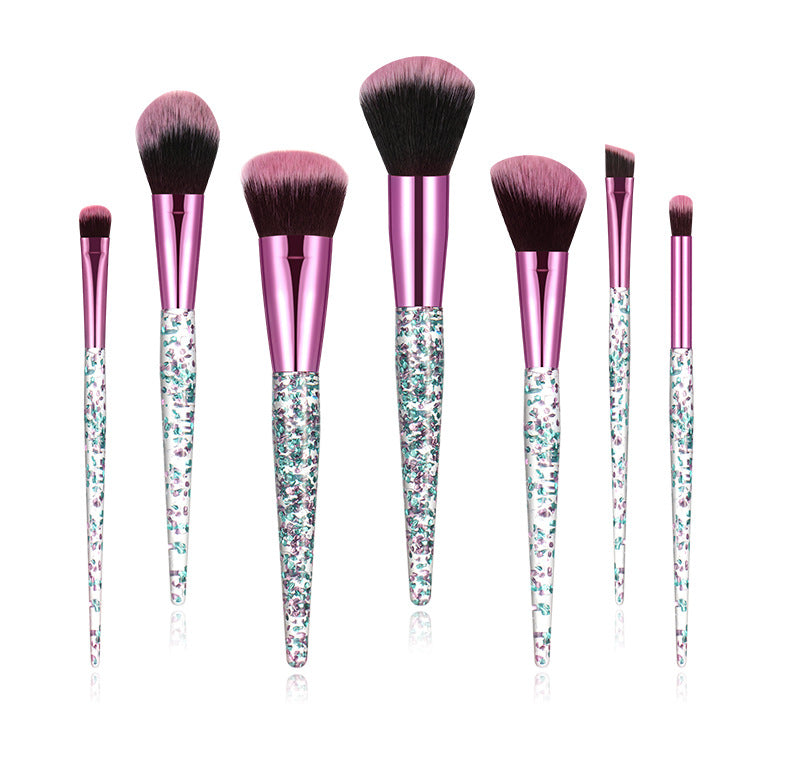 Set of makeup brushes with pink handles and glittery accents on a white background